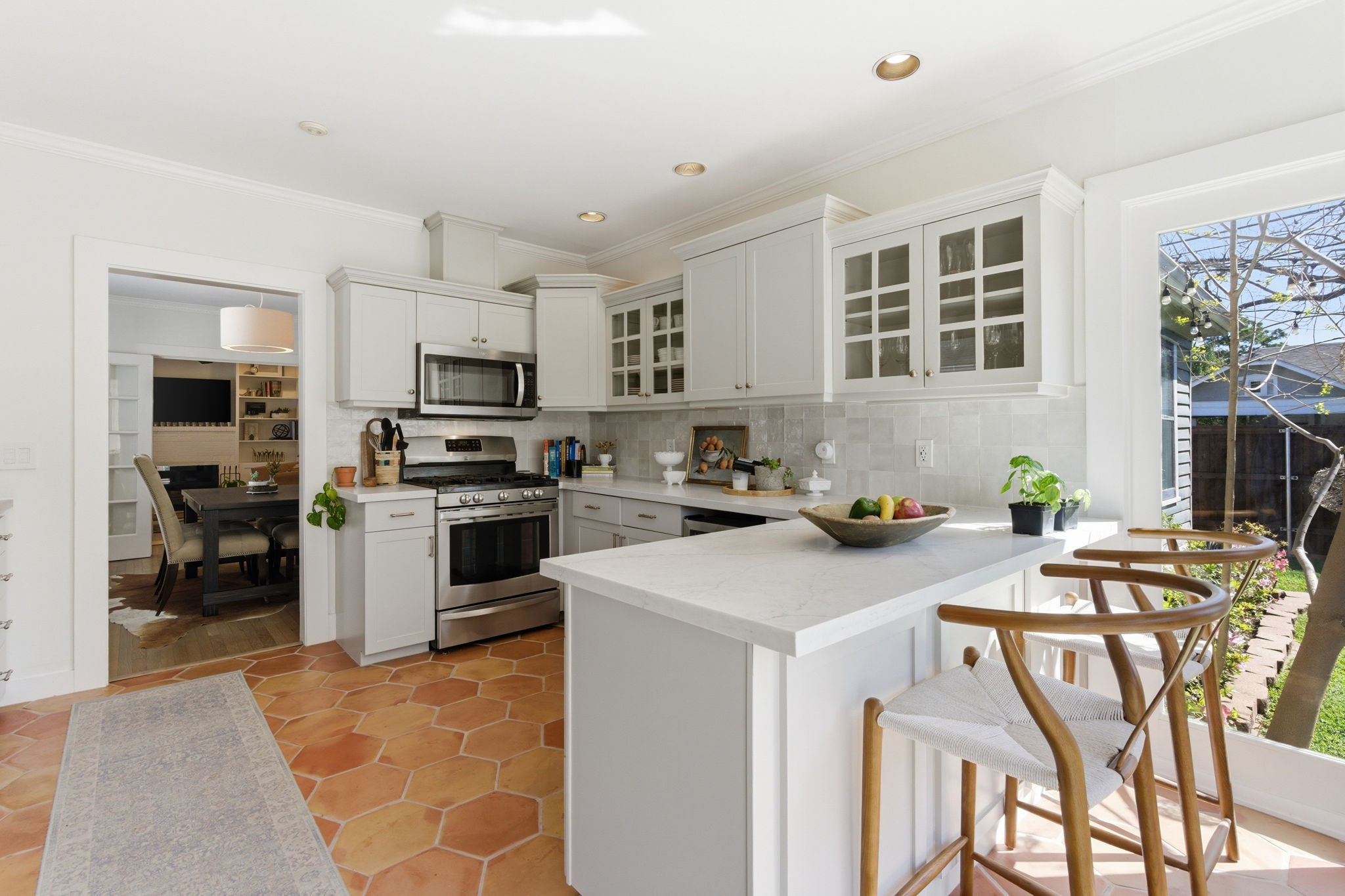 1002 West Cottage Street Houston, TX 77009 - Photo 10 of 37 Bright and inviting kitchen featuring granite countertops, a center island, and abundant cabinetry for storage. Large windows bring in natural light and create an open, airy feel throughout the space. Functional layout offers plenty of prep space and easy flow to adjacent living and dining areas.