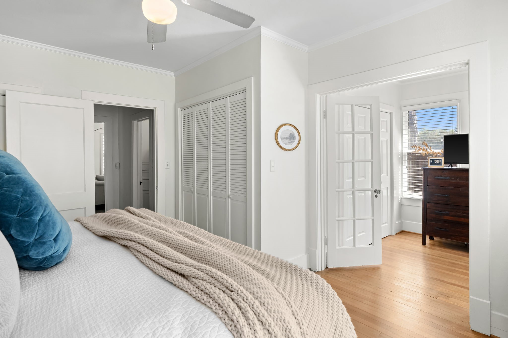 1002 West Cottage Street Houston, TX 77009 - Photo 17 of 37 From this angle, you can see the double closet configuration, direct hallway and bathroom access, and a French door leading to the adjacent sitting area. The layout keeps the primary bedroom private while staying connected to the main areas of the home. Hardwood floors continue seamlessly from the living spaces into this room.