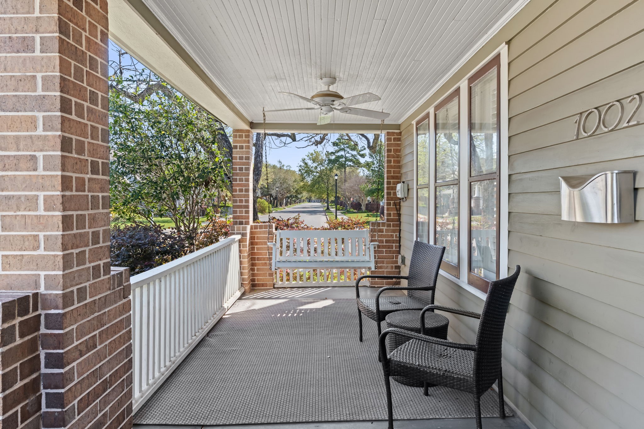 1002 West Cottage Street Houston, TX 77009 - Photo 2 of 37 The covered front porch includes a porch swing, ceiling fan, and views straight down the tree-canopied street, a true extension of living space in this neighborhood. It's the kind of spot that makes coming home feel different than pulling into a garage. This corner-lot position means extra airflow and sightlines in every direction.