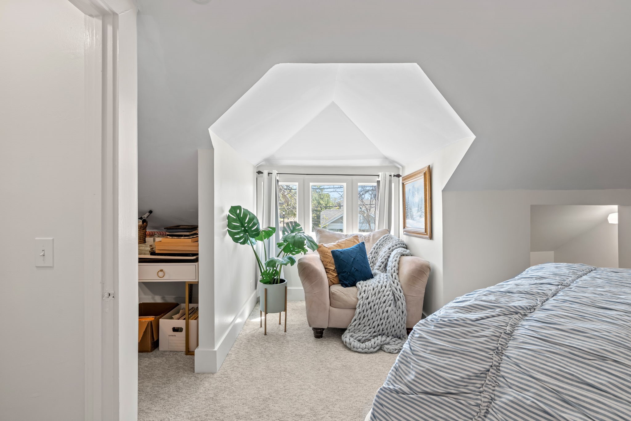 1002 West Cottage Street Houston, TX 77009 - Photo 20 of 37 This alternate angle of the third bedroom shows the charming dormer window nook with built-in natural light from three sides a great reading or lounging spot. The closet entry and additional eave storage are visible to the left, making the most of the roofline. Between the vaulted ceiling, en-suite bath, and this kind of architectural detail, the upstairs feels like its own private retreat.