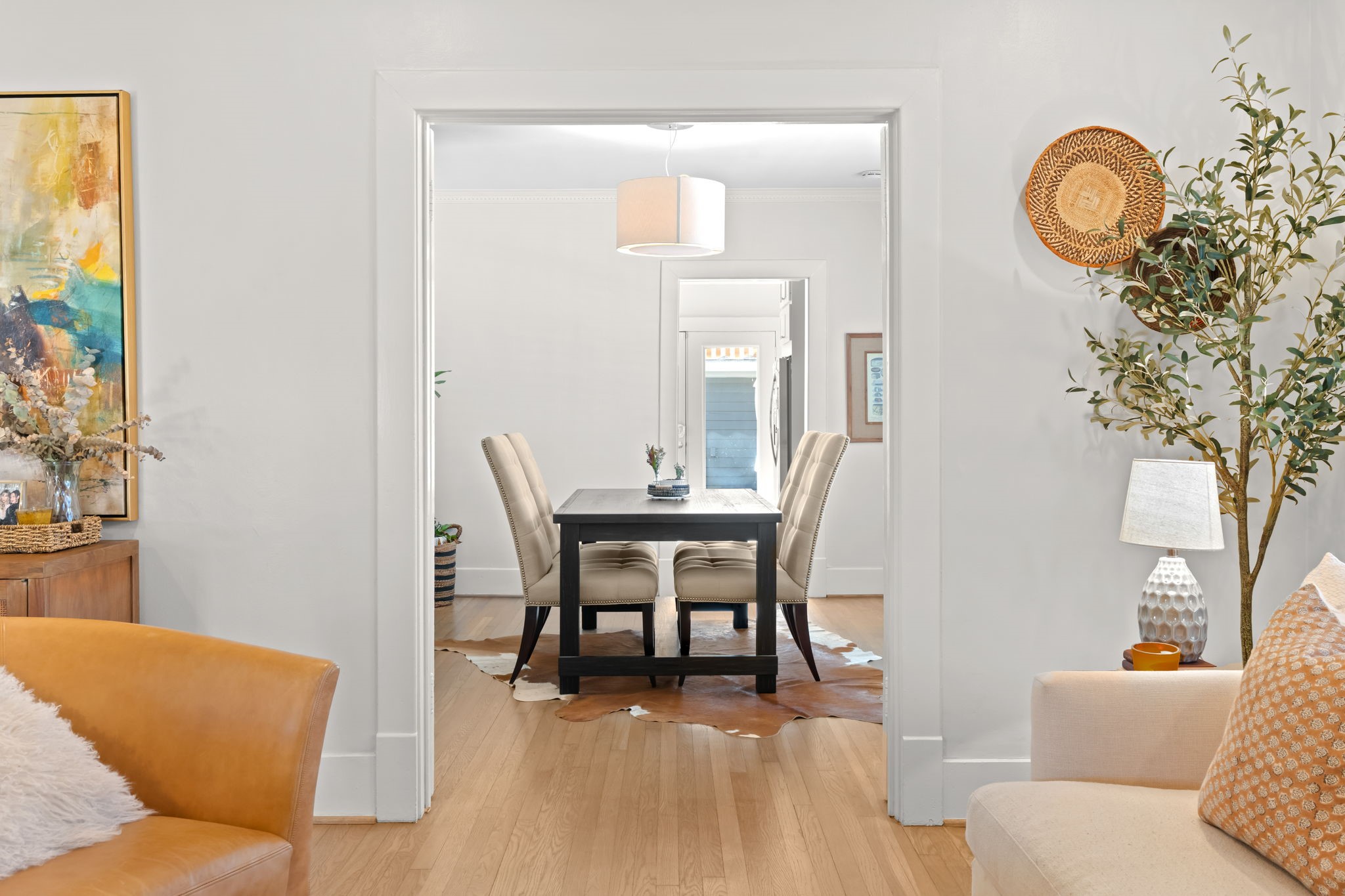 1002 West Cottage Street Houston, TX 77009 - Photo 7 of 37 From the living room, you can see directly into the formal dining room through a generous cased opening, with the kitchen visible beyond. This sightline shows how the three main living spaces connect in sequence living, dining, kitchen without feeling like one large open room. Hardwood floors run continuously through all three areas.