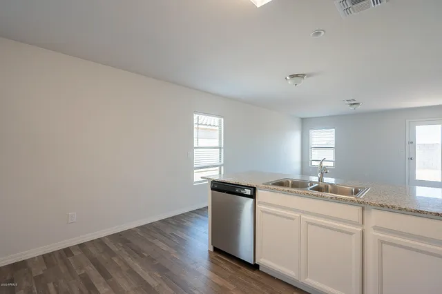 a kitchen with a sink cabinets and wooden floor