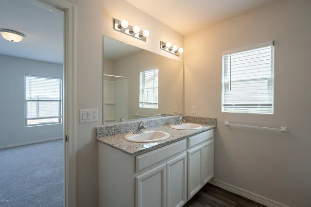 a bathroom with a granite countertop sink a mirror and a window