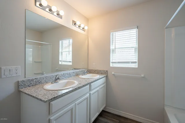 a bathroom with a granite countertop sink a light fixture and a mirror