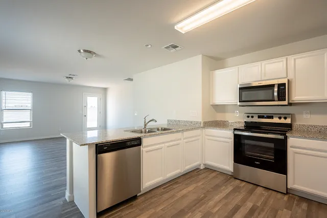 a kitchen with stainless steel appliances white cabinets a sink and a stove