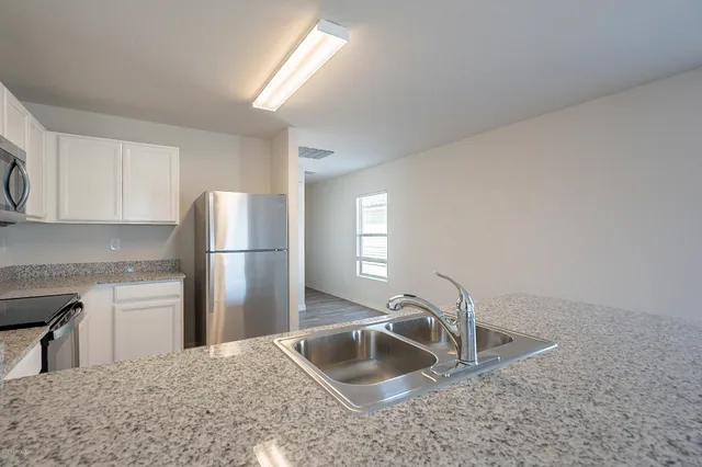 a kitchen with refrigerator cabinets and a sink