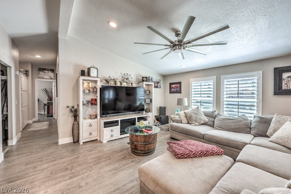 4375 Pinwheel Street Logandale, NV 89021 - Photo 17 of 52 Relax in the open-concept living space, featuring recessed lighting, a modern ceiling fan, and durable plank flooring.