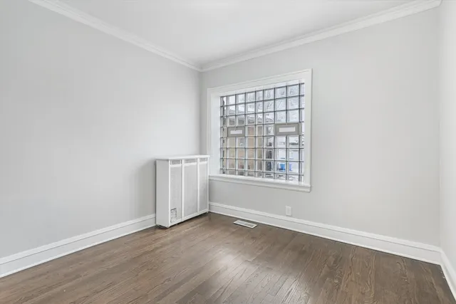 an empty room with wooden floor and window