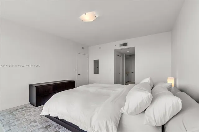 a bedroom with a bed and a night stand