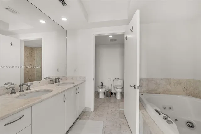 a spacious bathroom with a tub sink and mirror