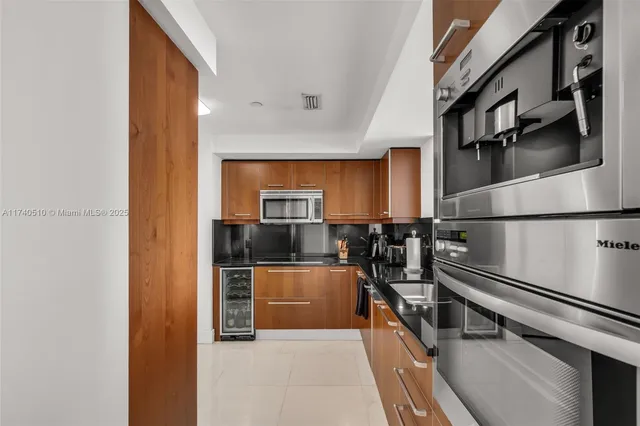 a kitchen with stainless steel appliances granite countertop a refrigerator and a stove top oven