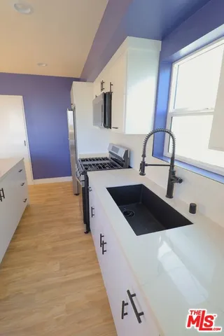 a kitchen with a sink a stove and a mirror