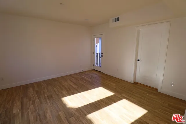 a view of an empty room and wooden floor