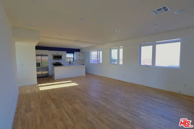 a view of a living room hardwood floor and a kitchen