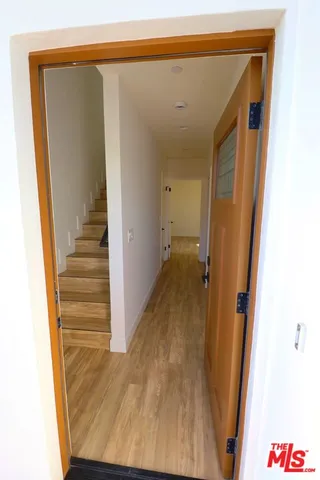 a view of a hallway with wooden floor and entryway