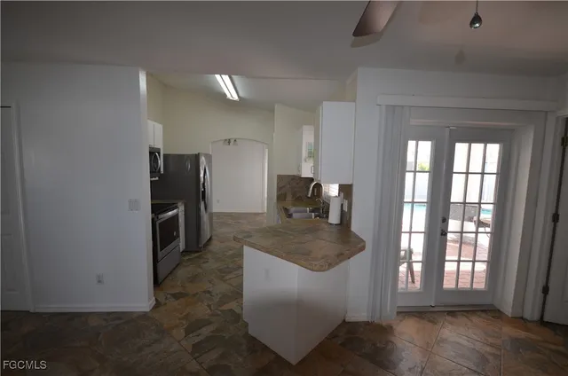 a large kitchen with granite countertop a refrigerator and a stove top oven