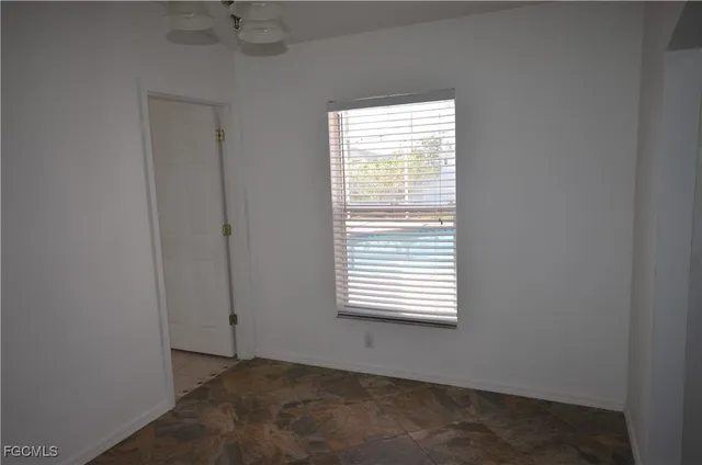 a view of a chandelier in big room with windows and entryway