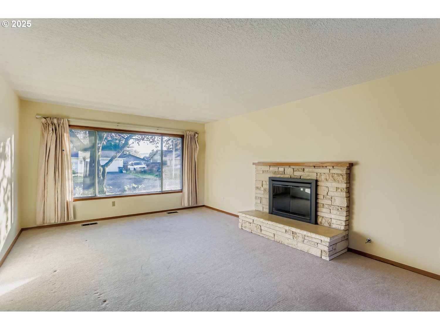 1134 South Ginger Street Cornelius, OR 97113 - Photo 6 of 25 a view of an empty room with a fireplace