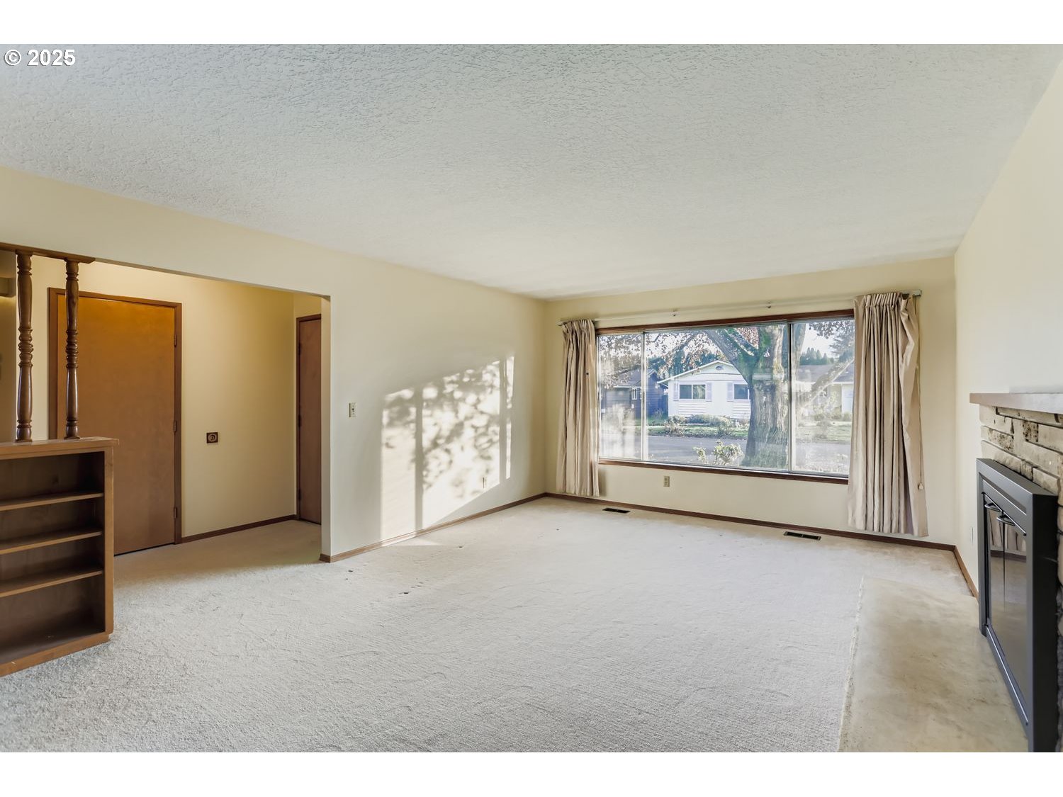 1134 South Ginger Street Cornelius, OR 97113 - Photo 7 of 25 a view of an empty room with a fireplace and a window