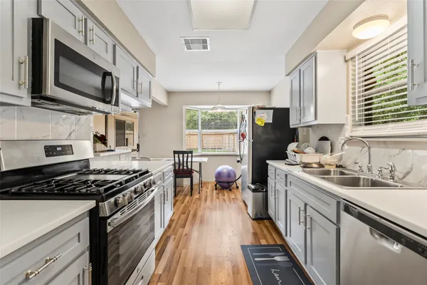 a kitchen with stainless steel appliances a stove sink microwave and cabinets