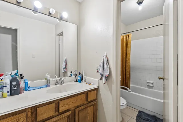 a bathroom with a bathtub sink vanity mirror and toilet