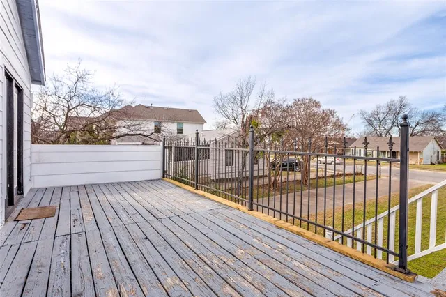 a view of a balcony with wooden floor and fence