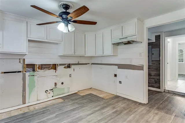 a kitchen with granite countertop white cabinets and white appliances