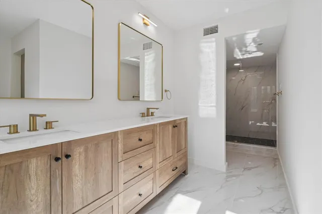a bathroom with a double vanity sink mirror and