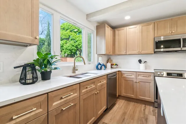 a kitchen with sink a window and cabinets