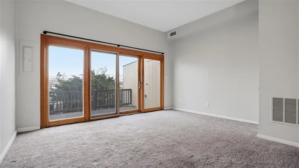 an empty room with windows and city view