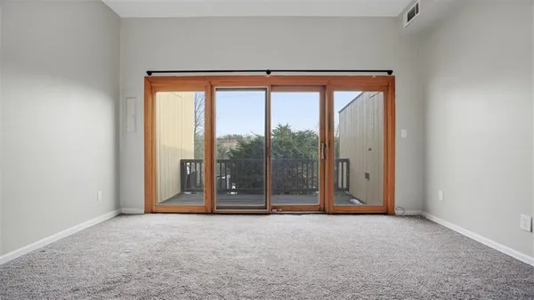 an empty room with sliding glass door and mountain view