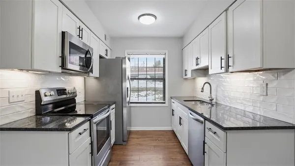 a kitchen with granite countertop stainless steel appliances and sink