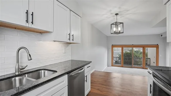 a kitchen with stainless steel appliances granite countertop a sink a stove and a counter space