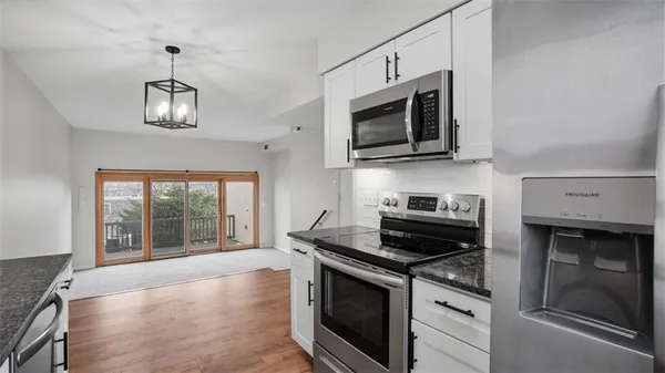 a kitchen with stainless steel appliances granite countertop a stove microwave and cabinets