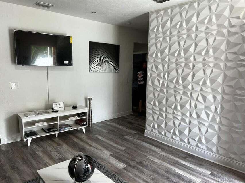 538 Southwest 7th Street Hallandale Beach, FL 33009 - Photo 7 of 17 a work room with furniture and a flat screen tv