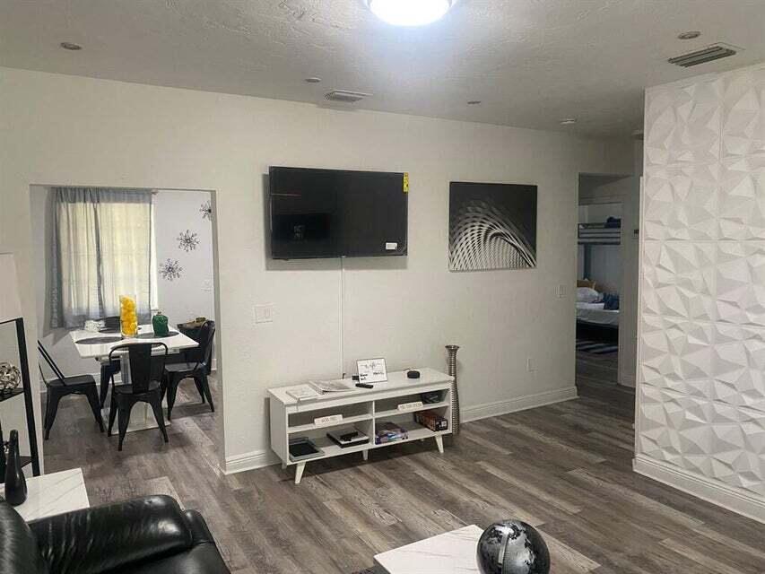 538 Southwest 7th Street Hallandale Beach, FL 33009 - Photo 8 of 17 a living room with furniture a flat screen tv and kitchen view