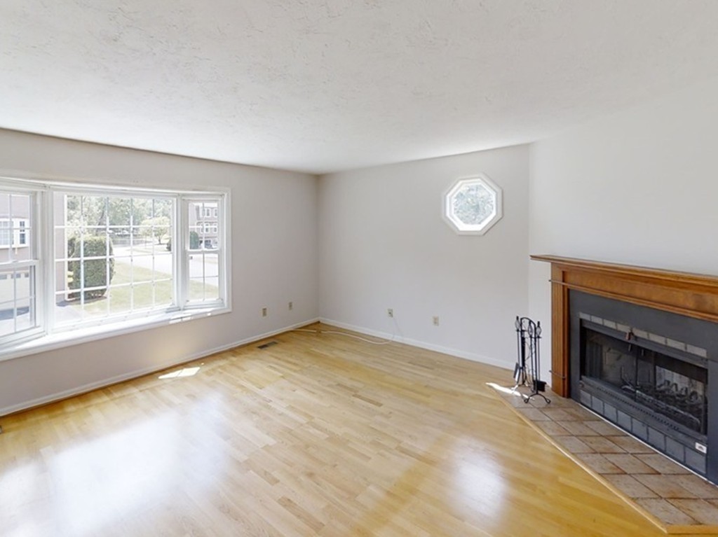 61 Heritage Drive, Unit 61 Tewksbury, MA 01876 - Photo 11 of 35 an empty room with a fireplace and window