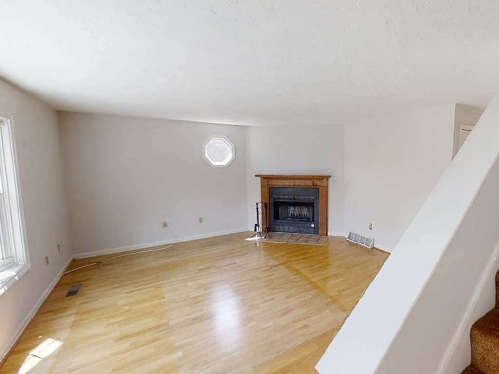 61 Heritage Drive, Unit 61 Tewksbury, MA 01876 - Photo 13 of 35 a view of empty room with wooden floor and fireplace