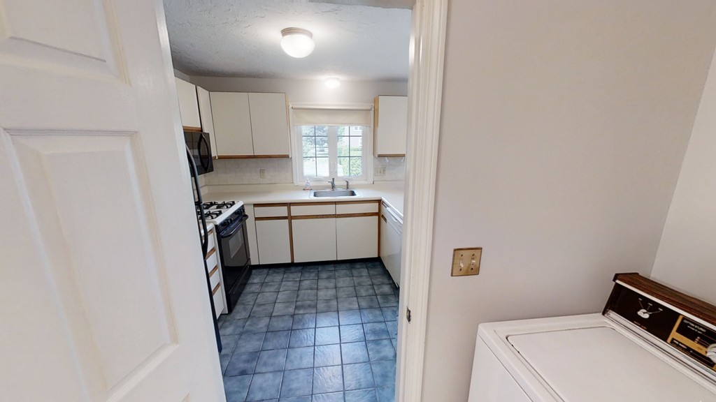 61 Heritage Drive, Unit 61 Tewksbury, MA 01876 - Photo 28 of 35 a kitchen with a sink a refrigerator and cabinets