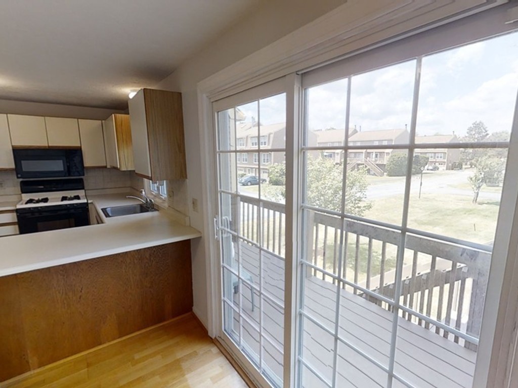 61 Heritage Drive, Unit 61 Tewksbury, MA 01876 - Photo 6 of 35 a kitchen with kitchen island a large window cabinets and a sink