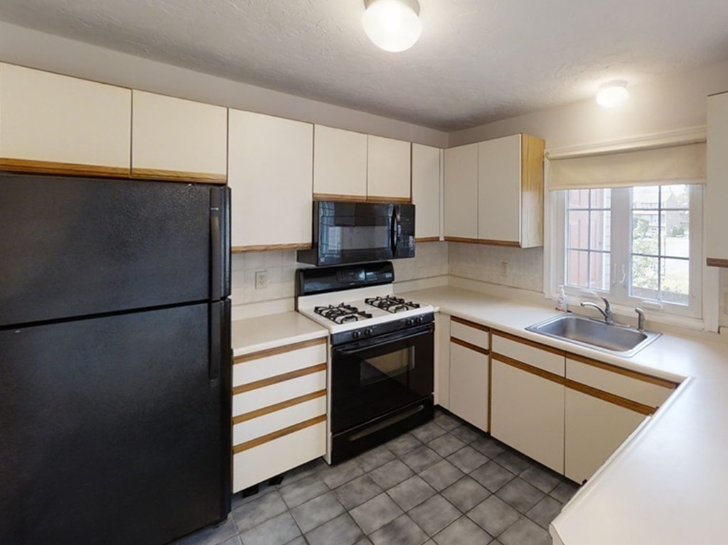 61 Heritage Drive, Unit 61 Tewksbury, MA 01876 - Photo 7 of 35 a kitchen with stainless steel appliances a refrigerator sink and microwave