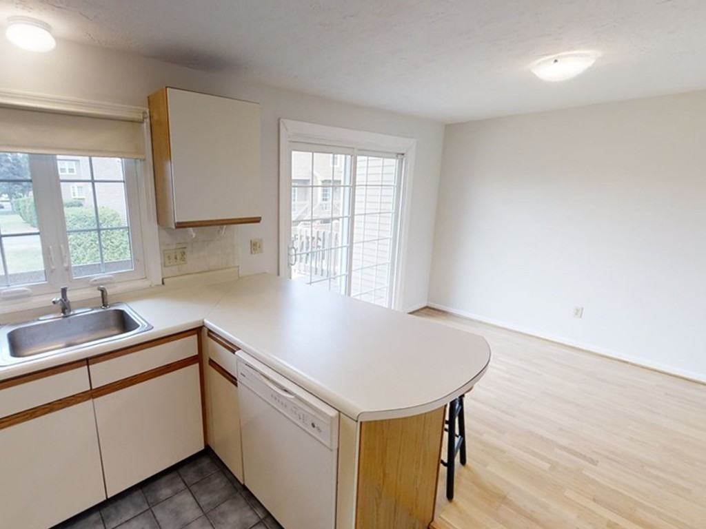 61 Heritage Drive, Unit 61 Tewksbury, MA 01876 - Photo 9 of 35 a kitchen with a sink cabinets and wooden floor