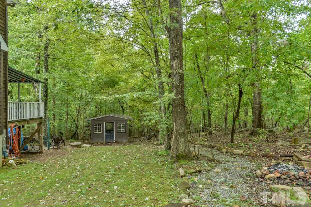 377 Booth Road Chapel Hill, NC 27516 - Photo 20 of 22 This view taken from the parking area shows you the lovely wooded area along the side of the house that leads to the garden/tool shed.
