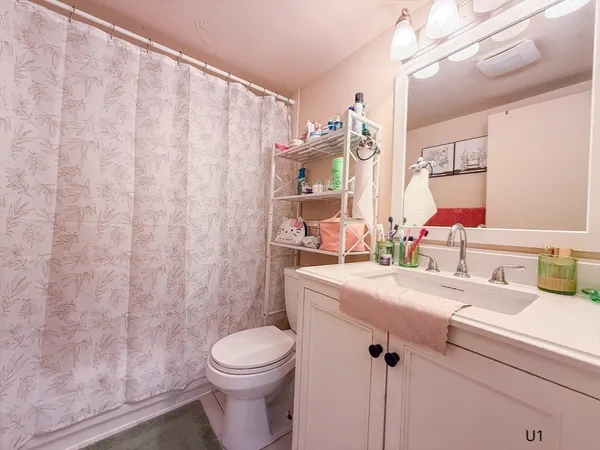 a bathroom with a toilet sink and mirror
