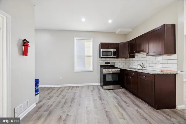 a kitchen with wooden floors and wooden cabinets