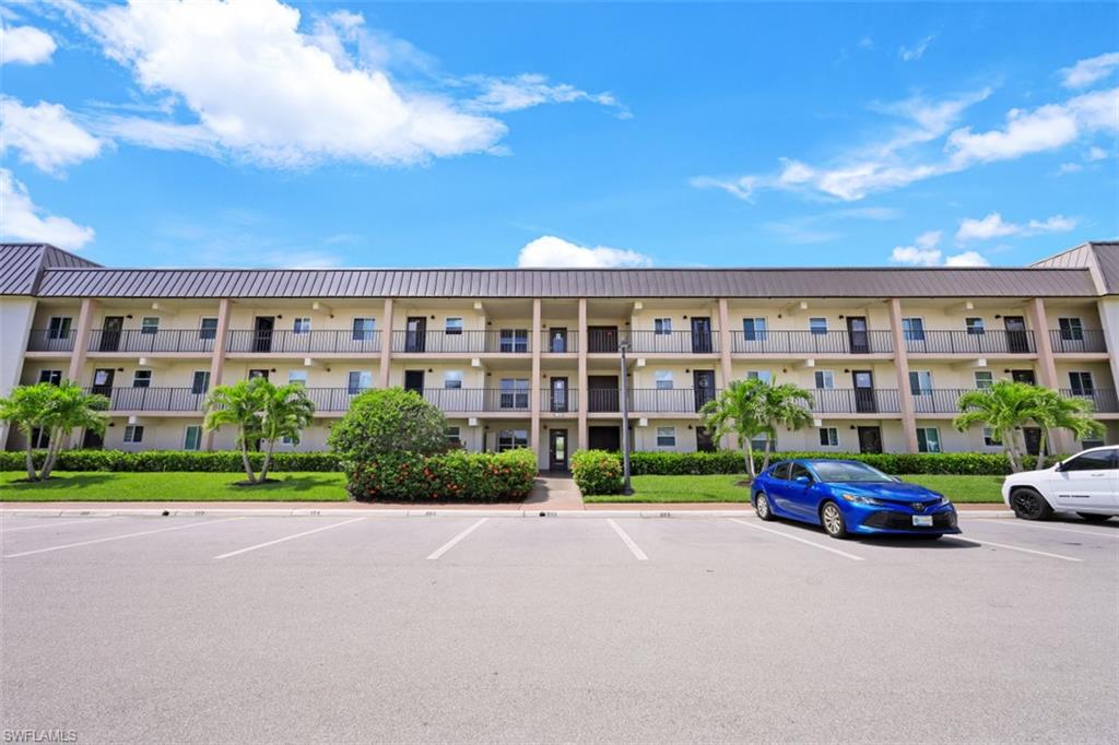 1010 Manatee Road, Unit B201 Naples, FL 34114 - Photo 1 of 24 a car parked in front of a brick house with a yard