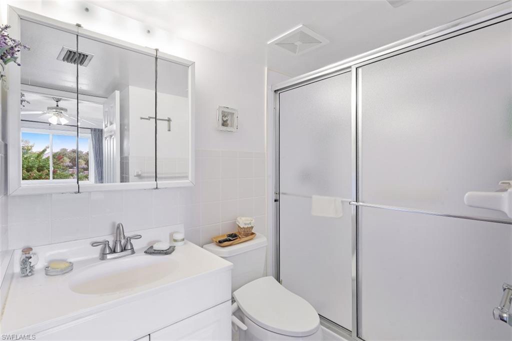 1010 Manatee Road, Unit B201 Naples, FL 34114 - Photo 12 of 24 a bathroom with a sink a toilet and shower