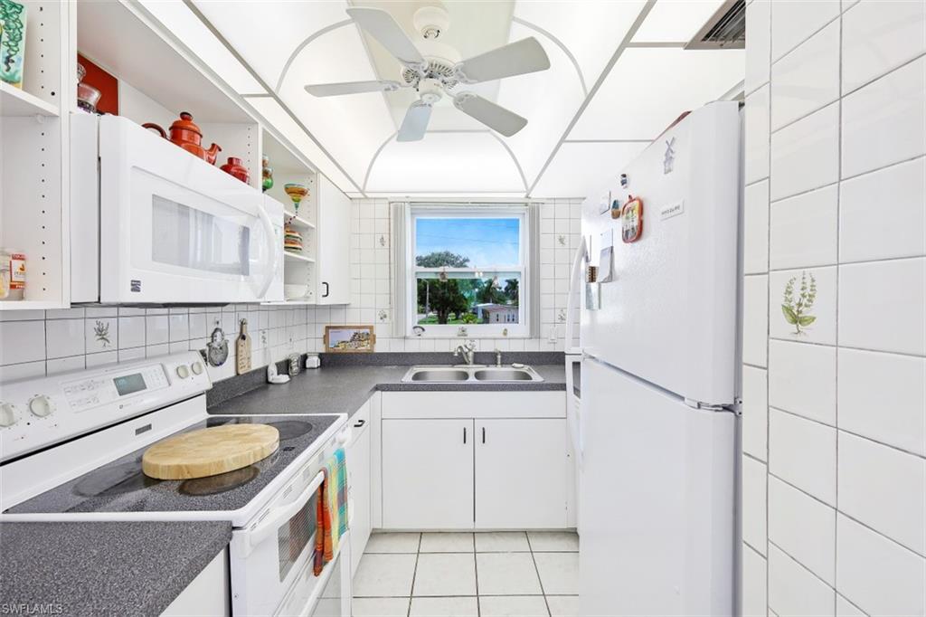 1010 Manatee Road, Unit B201 Naples, FL 34114 - Photo 6 of 24 a kitchen with a sink appliances and cabinets