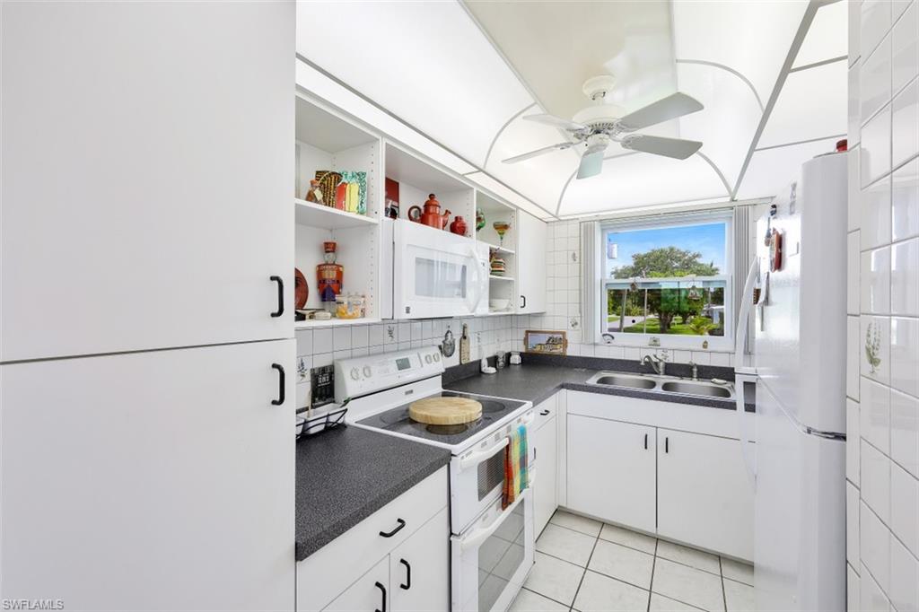 1010 Manatee Road, Unit B201 Naples, FL 34114 - Photo 7 of 24 a kitchen with a sink cabinets and window