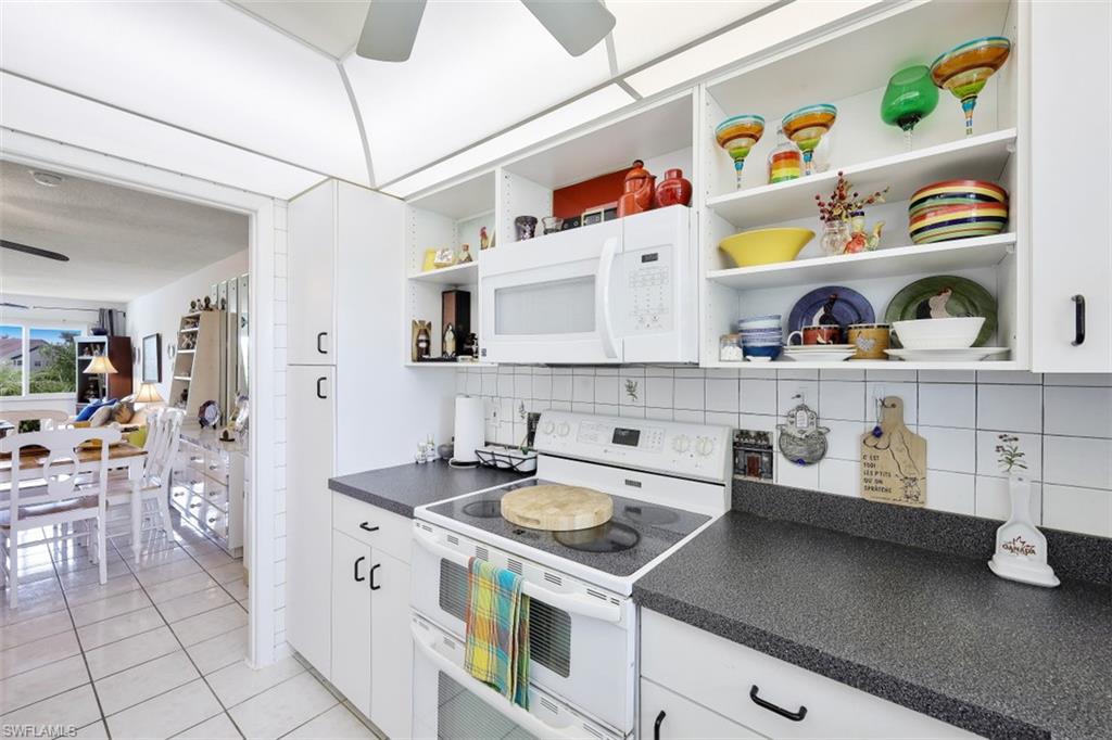 1010 Manatee Road, Unit B201 Naples, FL 34114 - Photo 8 of 24 a kitchen with white cabinets and wooden floor